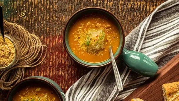 Bowls of winter soup and curry on a wooden table