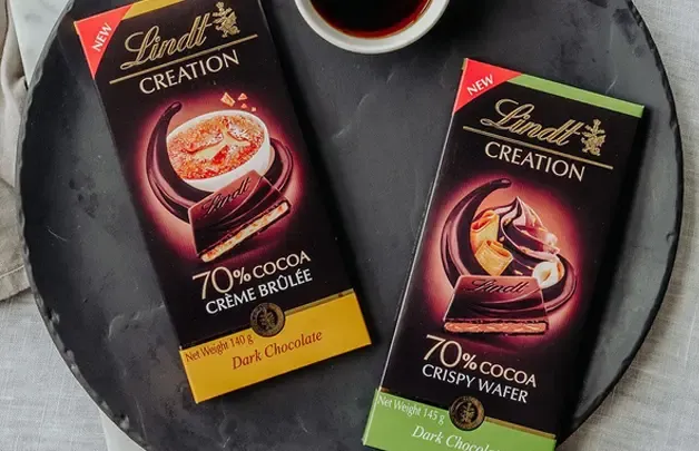 Two bars of Lindt Creation chocolate on a dark table