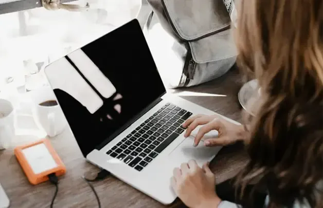 Two people working on laptops at a desk