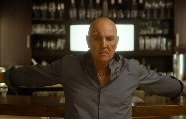 Actor Arnold Vosloo seated in a dimly lit room